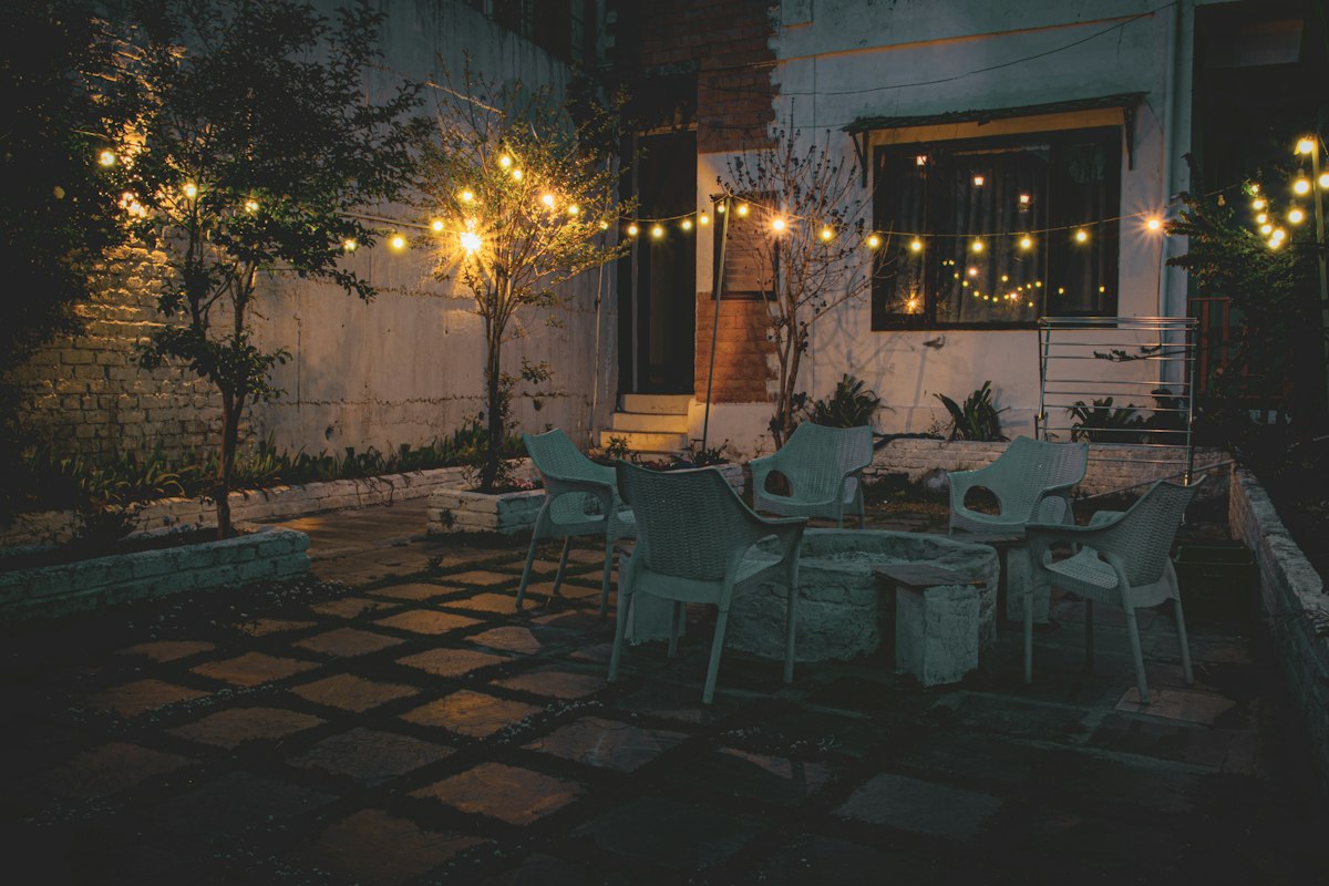 Evening patio with a dining table, chairs and string lights