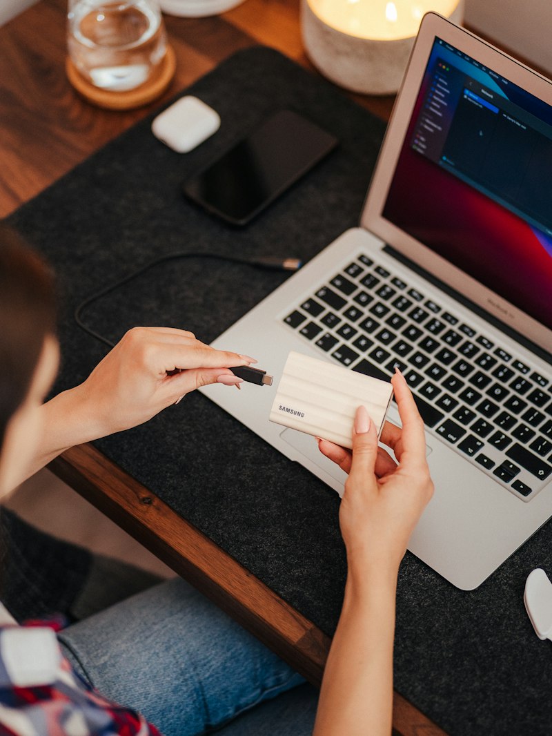 Hands holding a payment card while booking on a laptop
