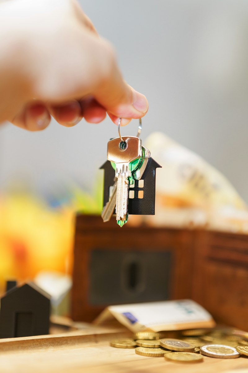 Hand holding house keys on a house-shaped keychain